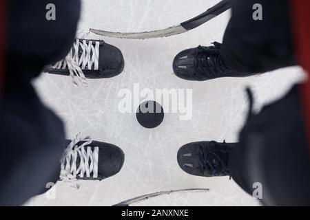 Vor Hintergrund der Ansicht von zwei unkenntlich Hockey Spieler stehen über Zupfen bereit Match auf Eis, kopieren, um Platz zu starten Stockfoto