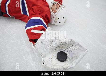 In der Nähe der weiblichen hockey player liegen auf Eis und Holding zupfen nach Praxis, kopieren Speicherplatz erschöpft Stockfoto