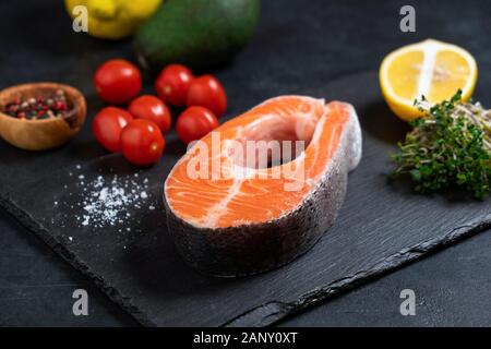 Rohen ungekochten Lachs Steak und Gewürzen auf Schiefer. Rote Fische Bereit zum Kochen Stockfoto