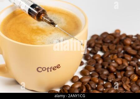 Tasse Kaffee, Kaffeebohnen und einer Spritze Nahaufnahme. Konzept der Kaffee sucht. Stockfoto