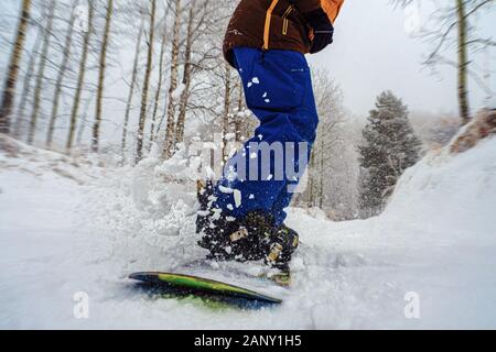 Nahaufnahme einer Snowboard gleitet mit Schnee spritzt. Snowboarders in den frischen Schnee. Stockfoto