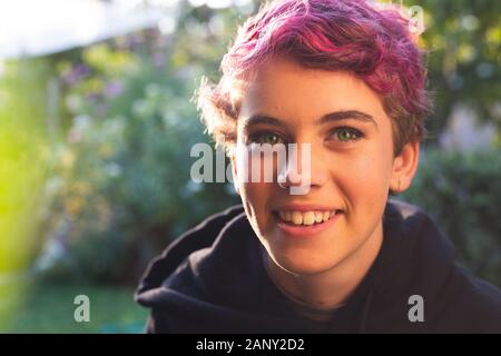 Portrait von glücklichen, lächelnden Teenager Mädchen mit kurzen Haaren in lebendigen, natürlichen Umgebung Stockfoto