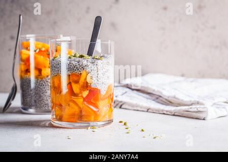 Chia Pudding mit Dattel und Kürbiskerne in Gläser, grauen Hintergrund. Gesunde vegane Ernährung Konzept. Stockfoto