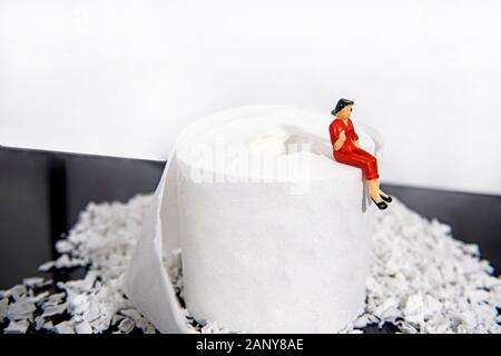 Abstrakte Foto mit WC-Papier und einige kleine Leute zahlen. Verschwendung von Zeit. Stockfoto