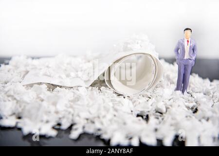 Abstrakte Foto mit WC-Papier und einige kleine Leute zahlen. Verschwendung von Zeit. Stockfoto