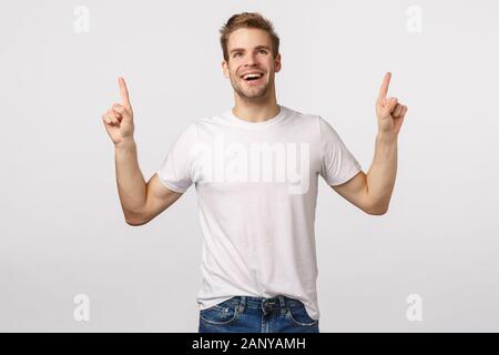 Beeindruckt, unbeschwerte Freude, lächelnden jungen Mann Gefühl Freude oder Glück, grinste erstaunt oder fragte sich, schaut verträumt, Beobachten Stockfoto