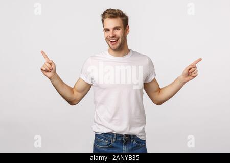 Stattliche ausgehende lächelnde blonde Kaukasier Männlich, Lachen unbekümmert und erfreut, haben große Chancen, zwei Möglichkeiten oder Optionen, seitlich Stockfoto