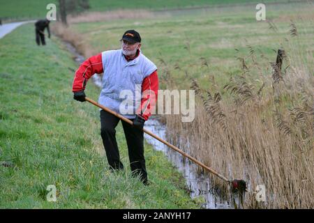 Nordenham, Deutschland. 18 Jan, 2020. Eine Bossel Player verwendet eine Krabbe (einem metallkorb an einem Griff) für Fische eine Bossel Kugel aus einem Graben. Foto: Michael Bahlo/dpa/Alamy leben Nachrichten Stockfoto