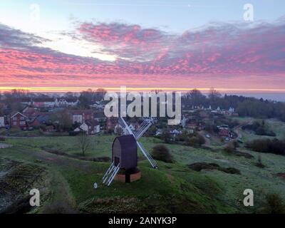 Die Sonne über dem Dorf Brill in der Nähe von Aylesbury in Buckinghamshire. Die Güteklasse II Liste* Windmühle aus dem 17. Jahrhundert. Stockfoto