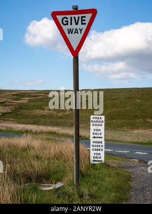 Zeichen: Weg geben, mit Eiern aus Freilandhaltung und selbst gebackenem Kuchen zum Verkauf, zwischen Gearstones und Hawes, North Yorkshire, England, UK gesehen Stockfoto
