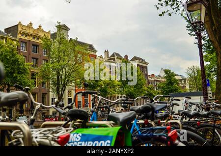 Amsterdam, Holland, August 2019. Fahrräder entlang der Grachten geparkt: Sie Frame die hübschen Häuser der Altstadt. Stockfoto