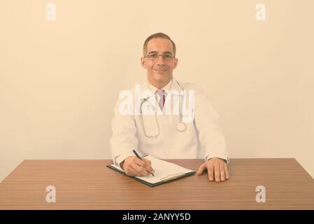 Portrait von Reifen persischen Mann Arzt hinter dem Schreibtisch Stockfoto