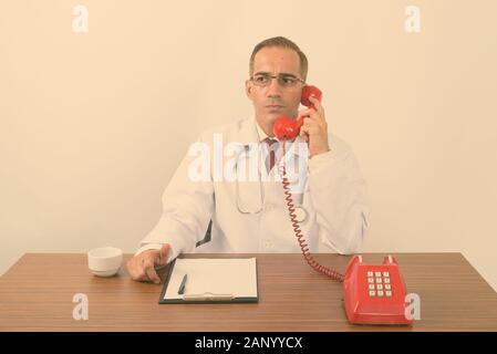 Portrait von Reifen persischen Mann Arzt hinter dem Schreibtisch Stockfoto
