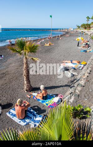 Kanarische Insel Teneriffa, SPANIEN - 27 Dez, 2019: Touristen sind entspannend und spielen auf einem Strand namens Playa El Beril auf Teneriffa. Ein Strand mit schwarzem Kies. Stockfoto