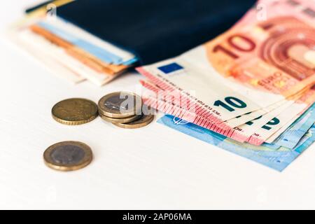 Nahaufnahme geld Euro-Banknoten in Blau Geldbeutel und Münzen auf weißem Hintergrund Stockfoto