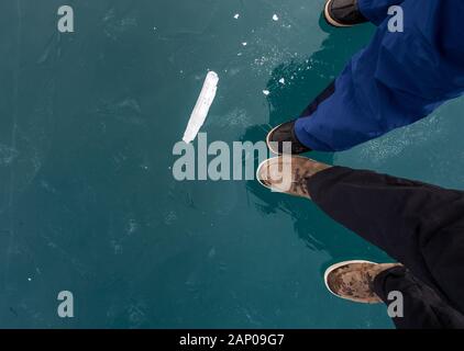 Wintershoes stehend auf gefrorenes Eis des Sees Oeschinensee in den Berner Alpen Stockfoto