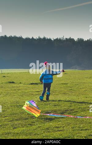 Kind flying a Kite im Freien an einem sonnigen klaren Tag in einem Land, Feld Stockfoto