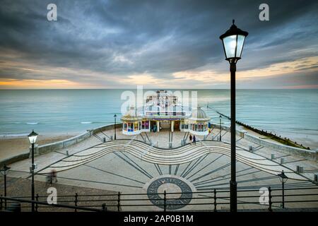Die strassenbeleuchtung Start auf, wie die Sonne in Cromer Pier zu kommen. Stockfoto