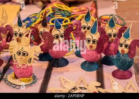 Indische traditionelle handgefertigte Puppen-Puppen aus Jute, isoliert auf verschwommenem Hintergrund, werden in einem Straßenladen zum Verkauf angeboten. Indisches Handwerk und Kunst Stockfoto