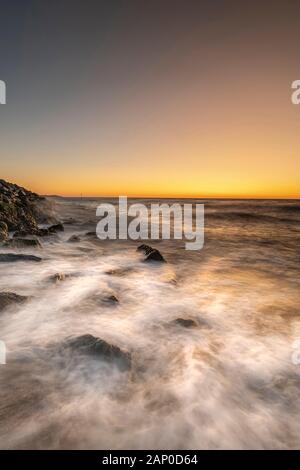 Sonnenaufgang über die Felsen am Ufer des Felixstowe in Suffolk. Stockfoto