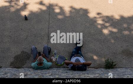 Zwei Männer, die Mittagspause und rast gegen Mauer in Arles in Frankreich. Stockfoto