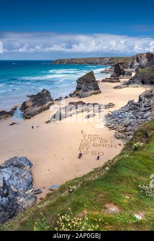 Eine Warnung in den Sand geschrieben am Strand von Bedruthan Steps auf der nördlichen Küste von Cornwall. Stockfoto