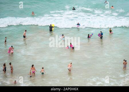 Urlauber Abkühlung im Meer in der heißen Sommer Wetter im Great Western Beach in Newquay in Cornwall. Stockfoto