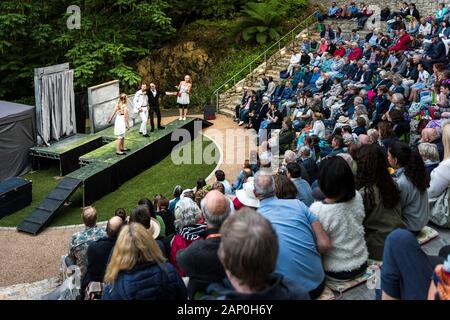 Das Publikum beobachtet Schauspieler, die EINEN Misummer Night's Dream im Trebah Garden Amphitheater in Cornwall spielen. Stockfoto