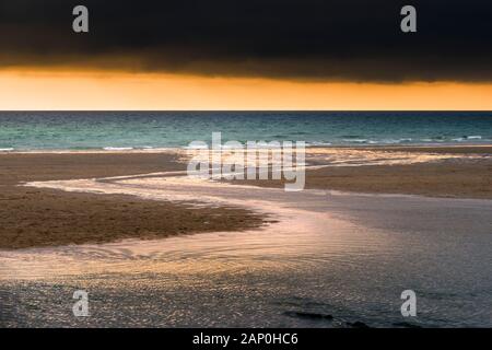 Eine dramatische Golden Sunset bei einer einsamen Fistral Beach in Newquay in Cornwall. Stockfoto