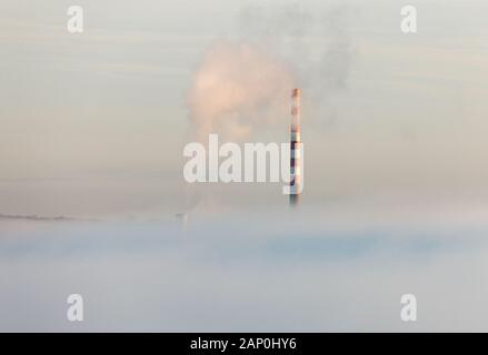 Aghada, Cork, Irland. 20. Januar, 2020. Schornsteine aus dem lokalen ESB Generatorstation Aufstieg über den frühen Morgen Nebel bei Aghada, Co Cork, Irland. - Gutschrift; David Creedon/Alamy leben Nachrichten Stockfoto