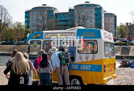 Die Menschen in der Warteschlange für Eis von einem traditionellen ice cream van an einem sonnigen Tag. Stockfoto