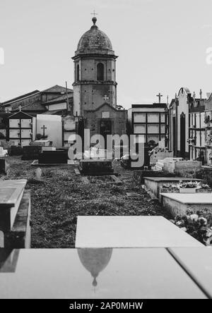 Die Kirche San Martin de Laspra spiegelt sich über einem Grab wider Stockfoto