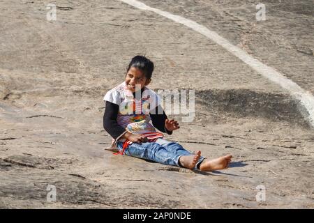 SITA RAPTAN INDIEN 10. JANUAR. 2020: Kleines Mädchen rutscht auf Felsen und hat Spaß. Stockfoto