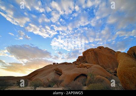 Felsformationen im Namibischen Spitzkoppe, kurz nach Sonnenaufgang, auf 02.03. 2019. Die Spitzkoppe Region und die umliegenden Seite Gipfeln mit ihren Felsformationen gehören zu einem der Wahrzeichen von Namibia, steigt sie auf eine Höhe von 1728 Meter über dem Meeresspiegel. Ein Paradies für Kletterer und Wanderer, die Gegend ist 120 Kilometer nordwestlich von Swakopmund und ist manchmal schwer zu erreichen. Die Bildung, die von weitem sichtbar wurde, war seit 100 Millionen Jahren durch vulkanische Aktivität, die erodiert Papiereinband rock, so dass heute nur die härteren Granitfelsen kann in seiner bizarren Formen gesehen werden erstellt. Stockfoto