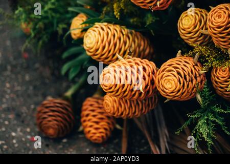 Blumenstrauß aus goldenen Beehive Ginger in einem Korb auf dem Betonboden Stockfoto