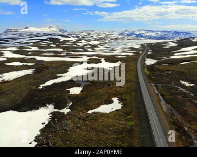 Luftbild eines teils verschneiten Gebietes auf der Route 92 in Richtung Seydisfjordur, Island Stockfoto