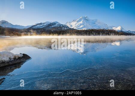 Sils See mit dem Piz da la Margna (3158 m) im Winter mit Dampfnebel. Graubünden, Schweiz Stockfoto