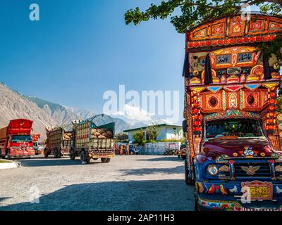 Farbenfroh dekorierte und lackierte Lastwagen fahren auf den staubigen Straßen des Karakorum Highway Stockfoto