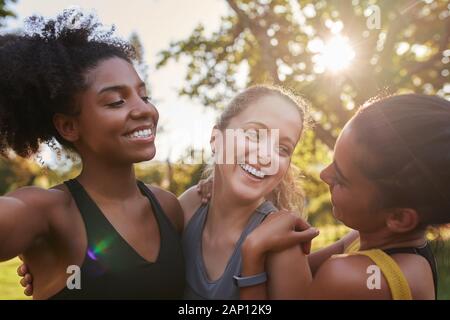 Gruppe von diversen weiblichen Freunden lächeln und Spaß zusammen an einem sonnigen Tag in den Park-glückliche fitness Freunde Lachen mit einander auf einem sonnigen Stockfoto