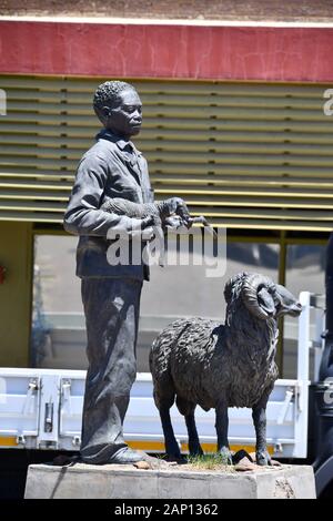 Bronze KARAKUL Statue in Keetmanshoop, am 22.02.2019, zeigt es eine Nama Hirt mit ein neugeborenes Lamm in seine Arme und einen Widder. Diese Statue ist sagte der Namibischen Karakulschaf Industrie zu symbolisieren. Die Skulptur erstellt, die von der namibischen Künstlerin Christina Salvoldi wurde am 13. September 2007 vorgestellt, das 100-jährige Jubiläum der Entwicklung der Karakul pelz Industrie in Namibia. Foto: Matthias Toedt/dpa-Zentralbild/ZB/Picture Alliance | Verwendung weltweit Stockfoto