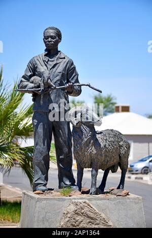 Bronze KARAKUL Statue in Keetmanshoop, am 22.02.2019, zeigt es eine Nama Hirt mit ein neugeborenes Lamm in seine Arme und einen Widder. Diese Statue ist sagte der Namibischen Karakulschaf Industrie zu symbolisieren. Die Skulptur erstellt, die von der namibischen Künstlerin Christina Salvoldi wurde am 13. September 2007 vorgestellt, das 100-jährige Jubiläum der Entwicklung der Karakul pelz Industrie in Namibia. Foto: Matthias Toedt/dpa-Zentralbild/ZB/Picture Alliance | Verwendung weltweit Stockfoto