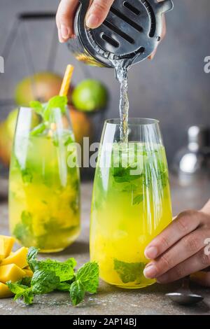 Frische mango mojito Cocktail mit Limetten und Minze im Glas Stockfoto