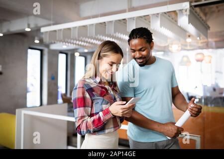 Kollegen diskutieren Geschäfts- und lächelnd während man durch das Büro Flur Stockfoto