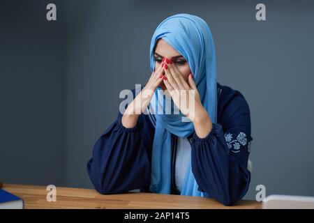 Unglücklich muslimische Studentin lernen Zuhause Stockfoto