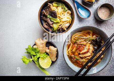 Satz serviert asiatische Suppen auf grauem Hintergrund der Ansicht von oben. Tom Yum Suppe, Aal Fischsuppe und Ramen Noodle Soup Stockfoto