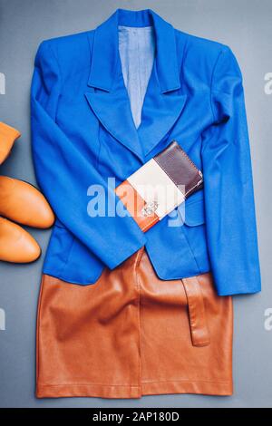 Classic blau trendige Farbe von 2020. Feder weibliche Kleidung Outfit. Stilvolle blaue Jacke, braune Schuhe Stiefel, Geldbörse Stockfoto