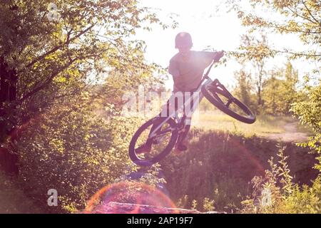 Coole Stunts von einem radprofi durchgeführt - Athlet. In einem Wald Sportplatz, mit Sprungschanzen, springen in den Himmel. Radfahren im Wald. Radfahren Stockfoto