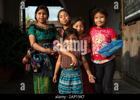 Gruppenfoto der Einheimischen, lokalen Kinder in Antigua, Guatemala. Einige tragen traditionelle Outfit, einige verkaufen handgefertigte Souvenirs. Dec 2018 Stockfoto