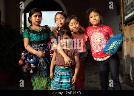 Gruppenfoto der Einheimischen, lokalen Kinder in Antigua, Guatemala. Einige tragen traditionelle Outfit, einige verkaufen handgefertigte Souvenirs. Dec 2018 Stockfoto