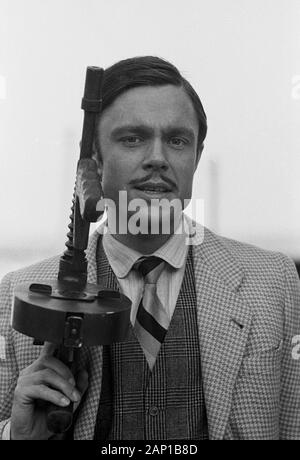 Jürgen Drews, deutscher Schlagersänger, mit Maschinengewehr als Mafioso, Deutschland um 1980. Deutsche Schlager Sänger Jürgen Drews spielen eine Mafia Mitglied mit einem Maschinengewehr, Deutschland um 1980. Stockfoto